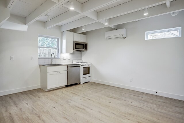 kitchen featuring appliances with stainless steel finishes, light hardwood / wood-style flooring, backsplash, white cabinets, and track lighting