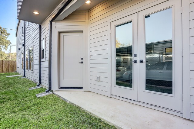 entrance to property featuring a yard and french doors