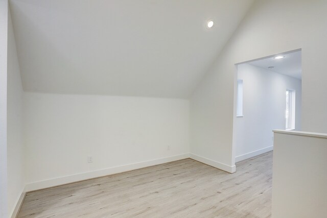 bonus room featuring light wood-type flooring and lofted ceiling