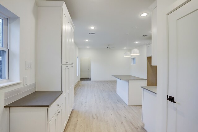 kitchen with ceiling fan, light hardwood / wood-style floors, pendant lighting, and white cabinetry