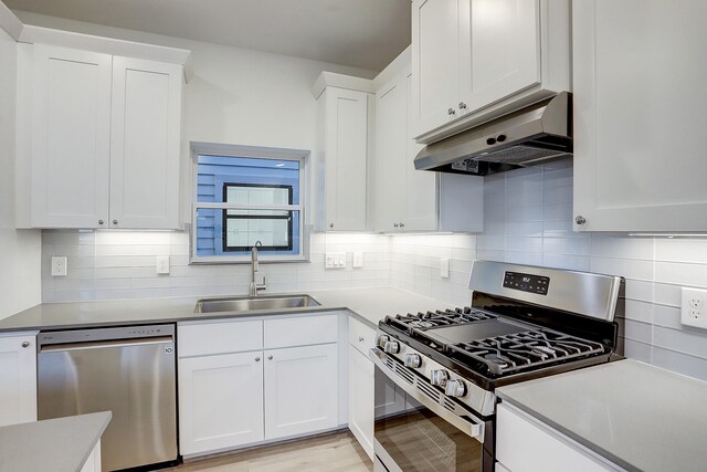 kitchen featuring sink, decorative backsplash, light hardwood / wood-style floors, stainless steel appliances, and white cabinets