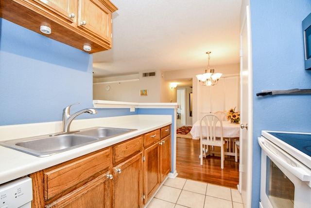 kitchen with a notable chandelier, a sink, white appliances, light tile patterned floors, and visible vents