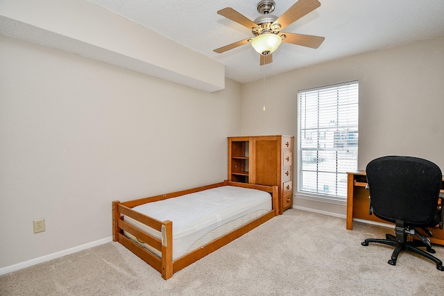 carpeted bedroom featuring baseboards, multiple windows, and a ceiling fan