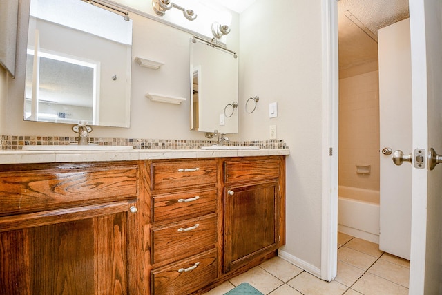 full bathroom featuring double vanity, a sink, and tile patterned floors