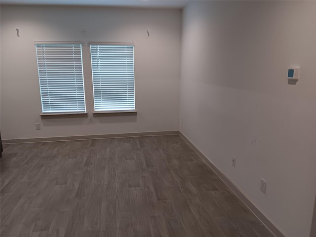 empty room with baseboards and wood finished floors
