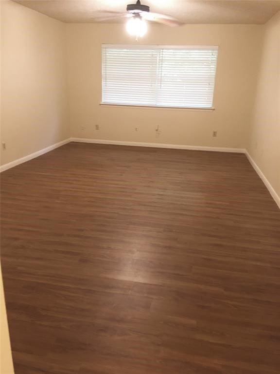 empty room featuring ceiling fan and dark hardwood / wood-style floors