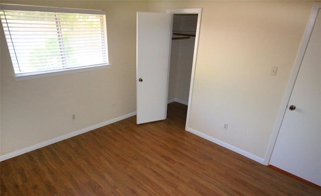 unfurnished bedroom featuring dark wood-type flooring and a closet