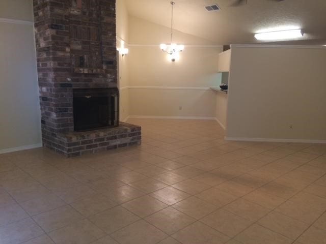 unfurnished living room with lofted ceiling, a chandelier, tile patterned floors, and a fireplace