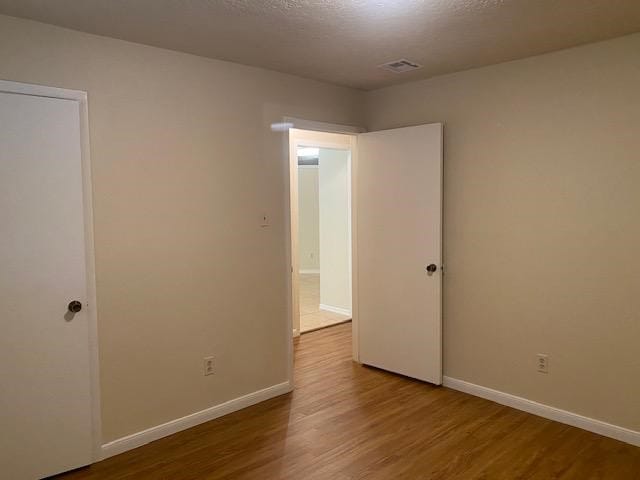 empty room with hardwood / wood-style flooring