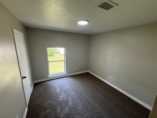 empty room featuring a textured ceiling and carpet