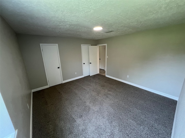 empty room with a textured ceiling and carpet