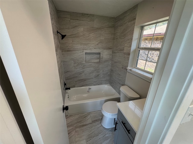 full bathroom featuring tile patterned flooring, toilet, tiled shower / bath combo, and vanity