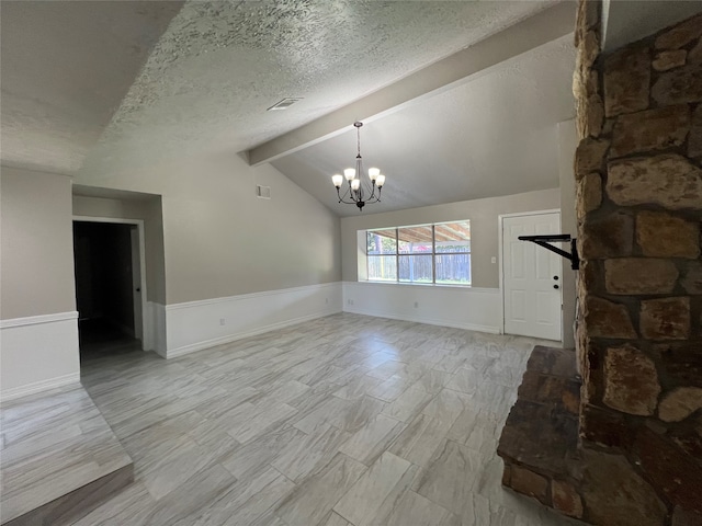 unfurnished living room featuring lofted ceiling with beams, an inviting chandelier, and a textured ceiling