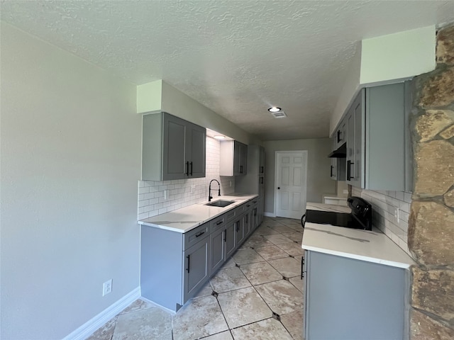 kitchen with sink, electric range, wall chimney exhaust hood, decorative backsplash, and light tile patterned floors