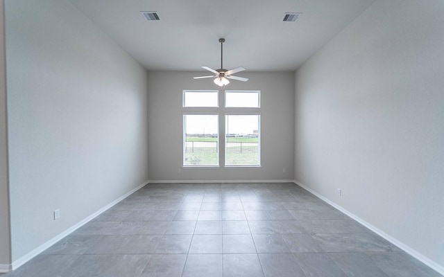 tiled empty room featuring ceiling fan