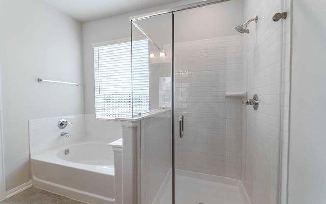 bathroom featuring plus walk in shower and tile patterned flooring