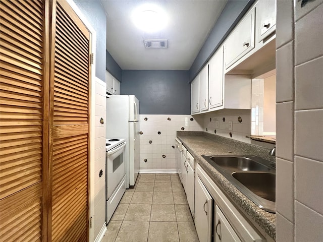 kitchen featuring light tile patterned flooring, sink, white electric range oven, tile walls, and white cabinetry