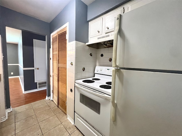 kitchen featuring decorative backsplash, white cabinets, light tile patterned flooring, white appliances, and under cabinet range hood