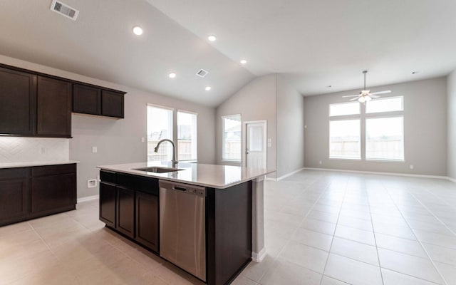 kitchen featuring sink, light tile patterned floors, stainless steel dishwasher, and an island with sink