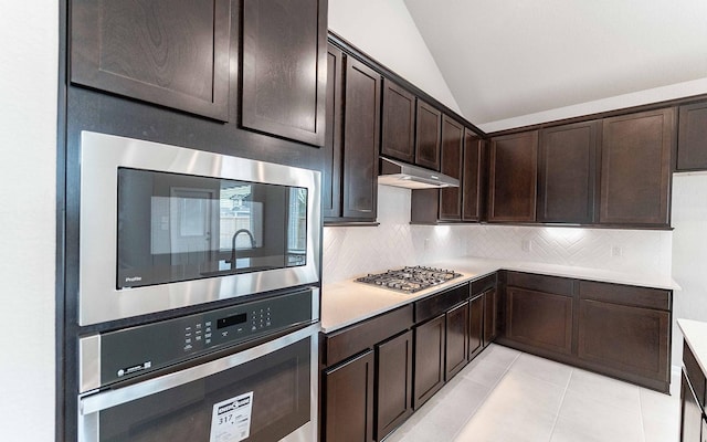 kitchen with tasteful backsplash, dark brown cabinetry, stainless steel appliances, and vaulted ceiling