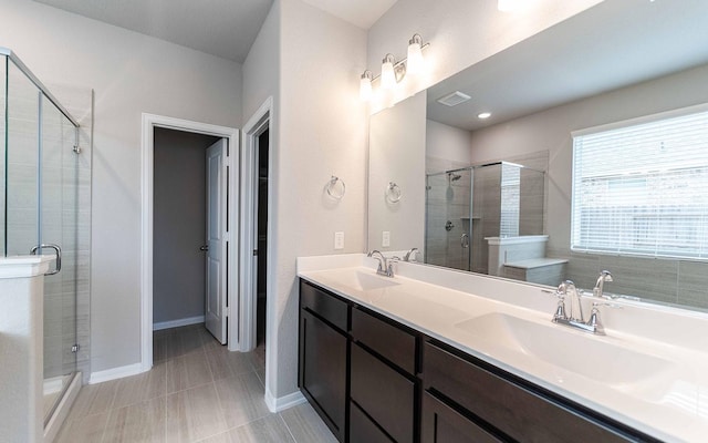 bathroom featuring a shower with door, vanity, and tile patterned floors