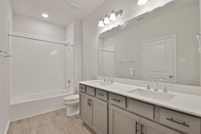 full bathroom featuring toilet, vanity, hardwood / wood-style flooring, and bathing tub / shower combination