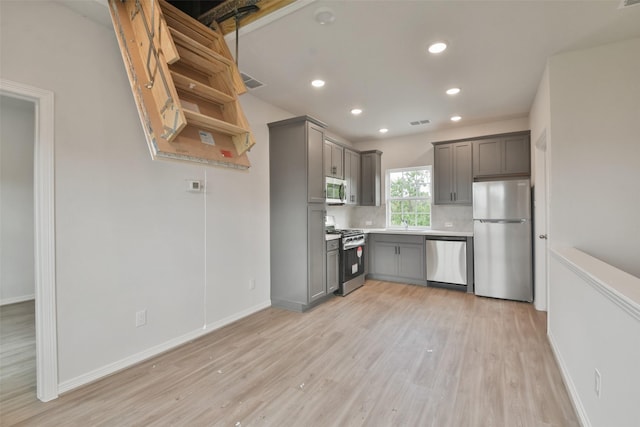 kitchen featuring gray cabinets, appliances with stainless steel finishes, and light hardwood / wood-style flooring