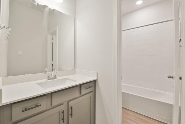 bathroom with bathing tub / shower combination, hardwood / wood-style floors, and vanity