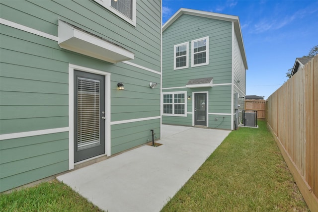 rear view of house with a yard, a patio, and central AC unit