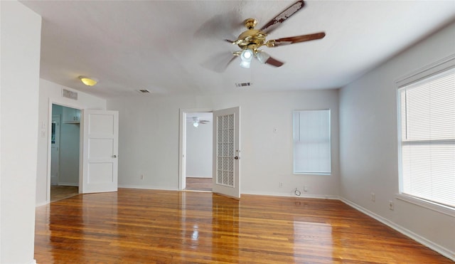 spare room featuring a wealth of natural light, visible vents, and wood finished floors