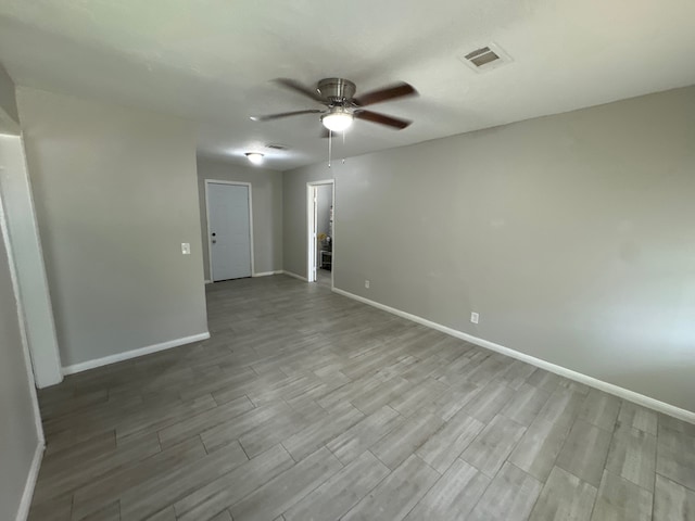 empty room with ceiling fan and light hardwood / wood-style floors