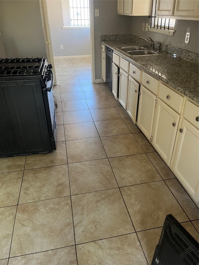 kitchen with sink, dark stone countertops, dishwasher, black gas stove, and light tile patterned flooring