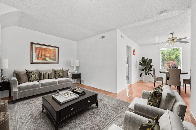 living room with ceiling fan, hardwood / wood-style flooring, and a textured ceiling