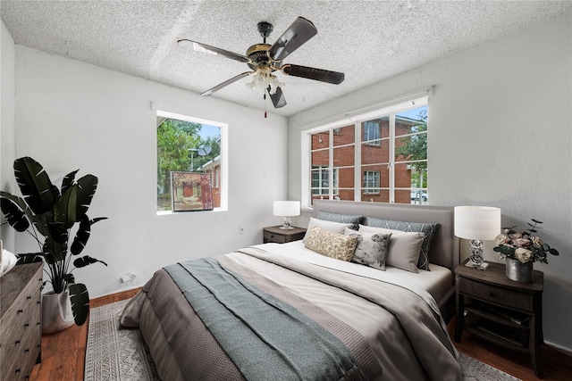 bedroom featuring a textured ceiling, ceiling fan, and hardwood / wood-style flooring