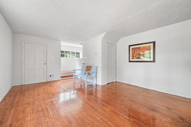 interior space featuring a textured ceiling and wood-type flooring