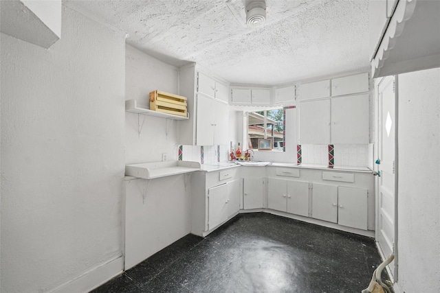 kitchen featuring sink, a textured ceiling, and white cabinetry