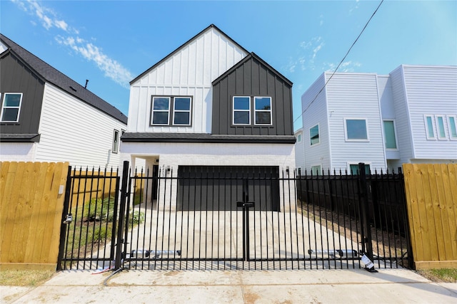 view of front facade featuring a fenced front yard, a gate, board and batten siding, and concrete driveway