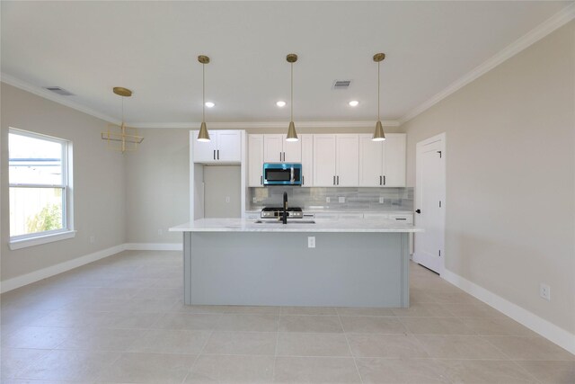 kitchen featuring light tile patterned flooring, hanging light fixtures, a kitchen island with sink, white cabinetry, and appliances with stainless steel finishes