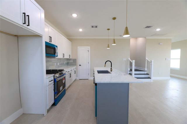 kitchen featuring white cabinets, pendant lighting, a center island with sink, sink, and stainless steel range