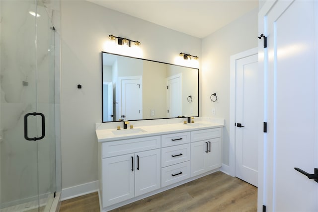 bathroom with hardwood / wood-style floors, walk in shower, and vanity