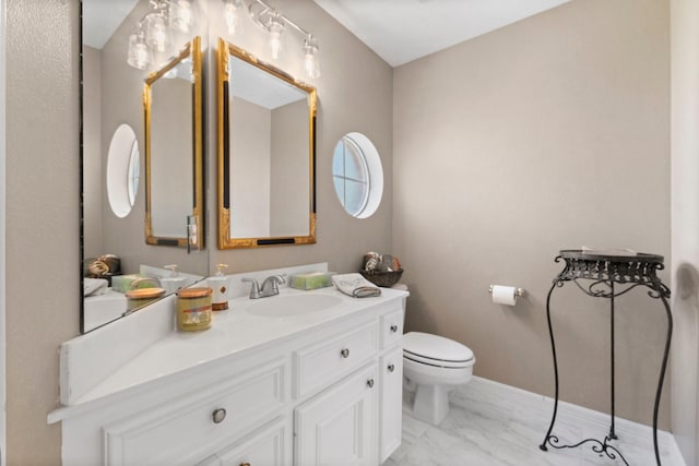 half bath featuring marble finish floor, baseboards, vanity, and toilet