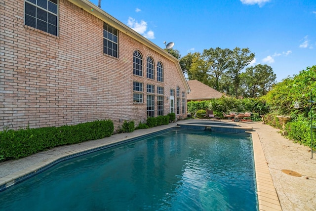 view of swimming pool featuring a pool with connected hot tub