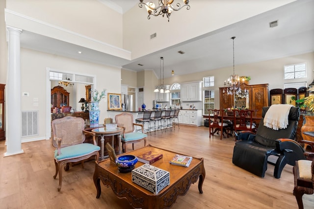 living room with light wood finished floors, visible vents, and a notable chandelier