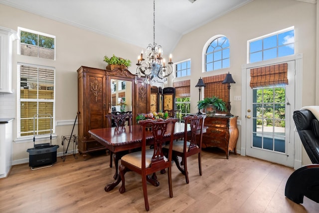 dining space with high vaulted ceiling, a wealth of natural light, and light wood-style flooring