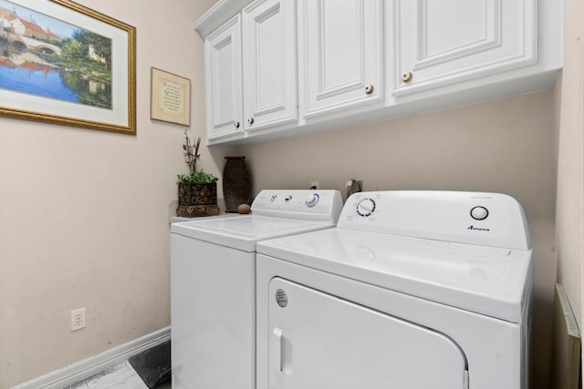 clothes washing area featuring cabinet space, baseboards, and separate washer and dryer