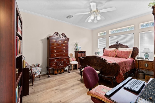 bedroom featuring light wood-type flooring, a ceiling fan, visible vents, and crown molding