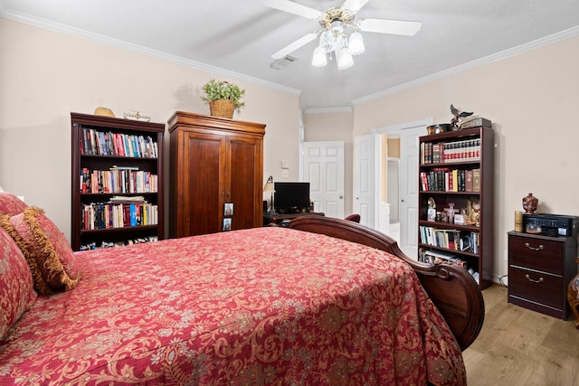 bedroom featuring ornamental molding, visible vents, light wood-style flooring, and a ceiling fan