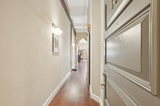 corridor with baseboards and dark wood-type flooring