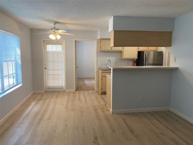 kitchen with ceiling fan, light brown cabinets, stainless steel fridge, and light hardwood / wood-style floors