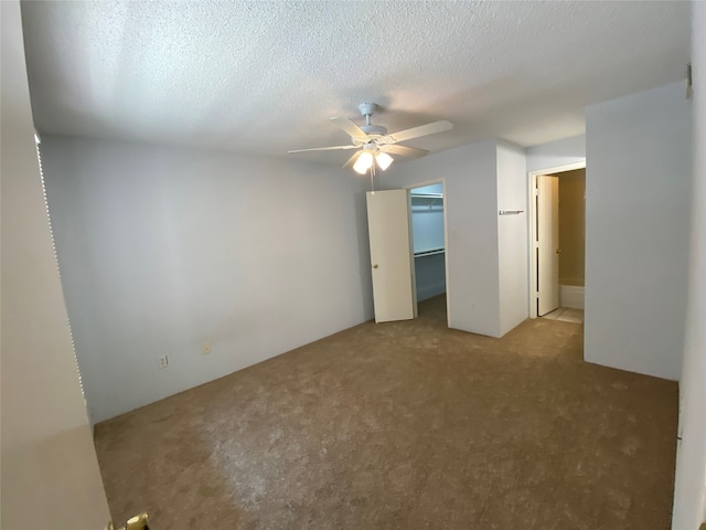 unfurnished room featuring a textured ceiling, ceiling fan, and light colored carpet